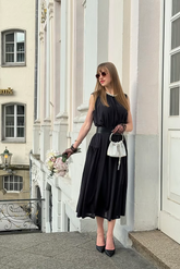 a lady in a black dress with a belt